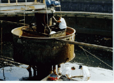 Three men working in a waste water treatment area